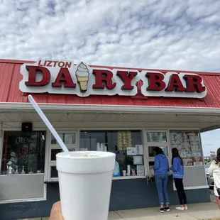 a hand holding a cup of ice cream