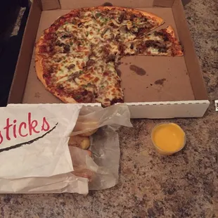 Sausage, green pepper, mushroom medium pizza with breadsticks (6) and cheese.