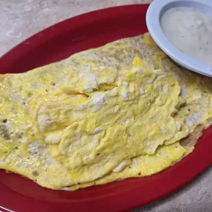 Loaded hash brown omelette with another 2 scrambled eggs piled on top. A side of gravy cuz gravy makes the world a better place.