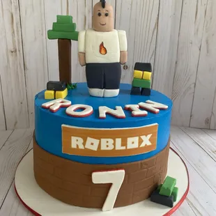 a lego man on top of a birthday cake