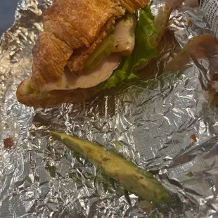 a croissant sandwich and pickle