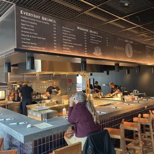 a restaurant counter with a menu on the wall