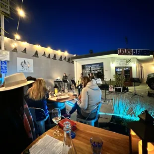 a group of people sitting outside at a restaurant