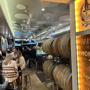 people sitting at tables in a wine cellar