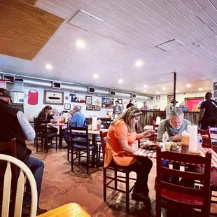 people sitting at tables in a restaurant