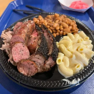 Three meat plate with moist brisket, jalapeño cheese sausage, and pulled pork. The sides were Mac and cheese and pinto beans.