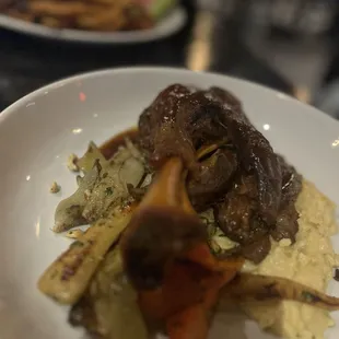 BRASIED LAMB SHANK+ Anderson Ranch lamb, creamy polenta, confit root vegetables, hazelnut gremolata, demiglace