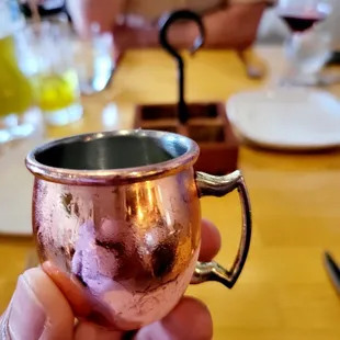 a hand holding a copper mug