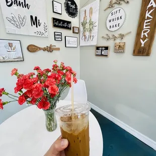 a person holding a cup of iced coffee