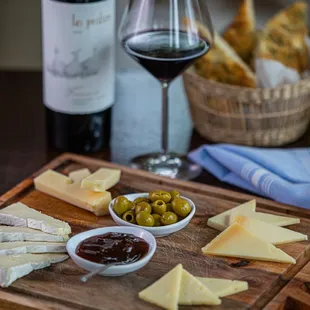 cheese, olives, and bread on a cutting board