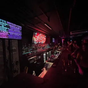 people sitting at a bar with neon lights
