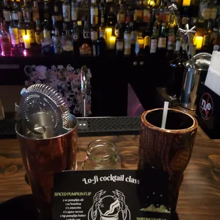 a menu and a drink at a bar