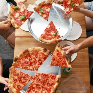 a group of people eating pizza