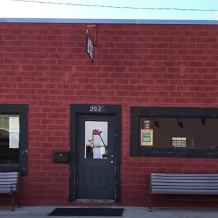 a red brick building with two benches in front of it