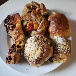 Assortment of pastries including a chocolate croissant, almond croissant, galette and a torsade.