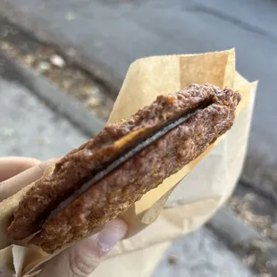 a hand holding a half eaten sandwich