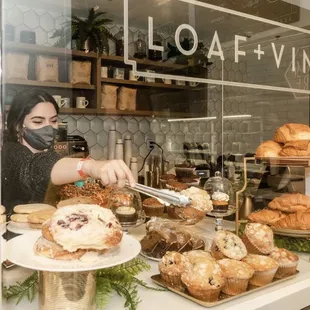 a woman in a face mask preparing pastries