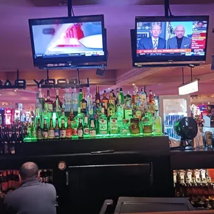 people sitting at the bar watching televisions