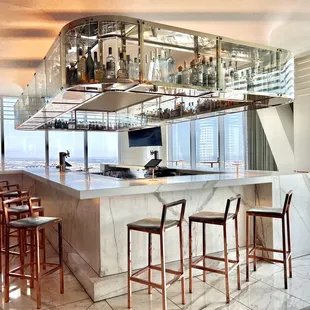 Marble bar with suspended glass shelf where liquor bottles are showcased. Views are awesome!