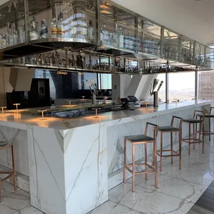a bar with marble countertop and bar stools