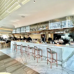 Marble bar with suspended glass shelf where liquor bottles are showcased.