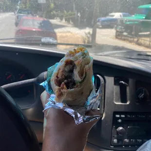 a hand holding a burrito