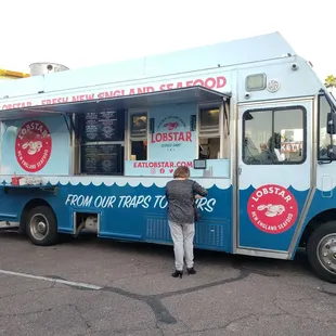 a woman standing in front of a food truck