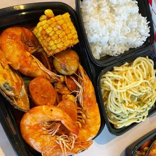 a meal of shrimp, pasta, corn, and rice