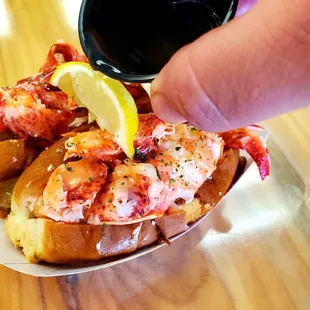 a hand grabbing a piece of lobster