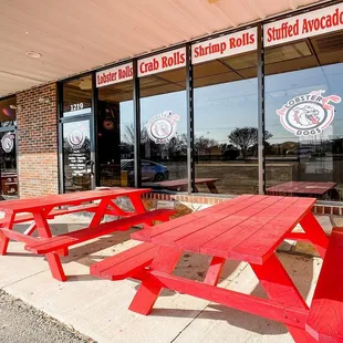 red picnic tables in front of a restaurant