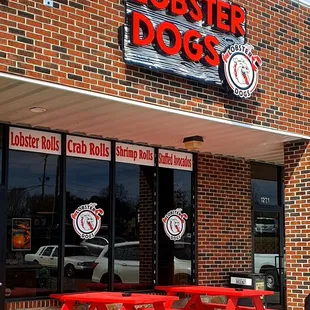 a red picnic table outside of the lobster dogs