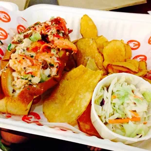 Lobster roll with chips and coleslaw.