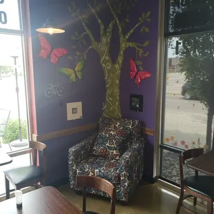 a living room with a tree mural on the wall