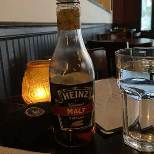 a glass of water and a bottle of heinz&apos;s