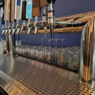 a row of wine glasses on a bar