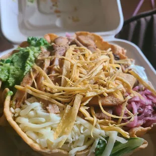 TACO SALAD- chicken, pickled onion sour cream cheese guacamole lettuce and refried beans at the bottom