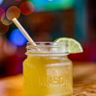 a mason jar of lemonade with a straw and a lime slice