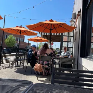 a woman sitting on a bench under an umbrella