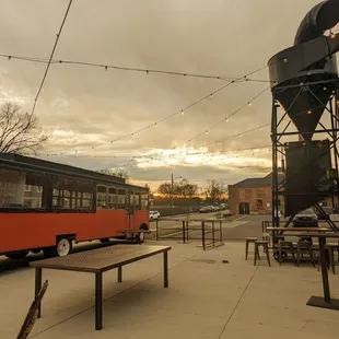 a red trolley parked in front of a brick building