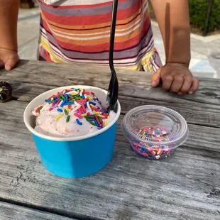 Single scoop of strawberry ice rest w/ sprinkles