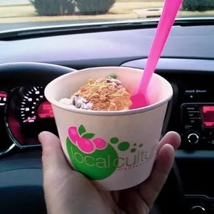 a hand holding a cup of ice cream