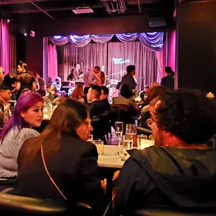 a group of people sitting at tables in a restaurant