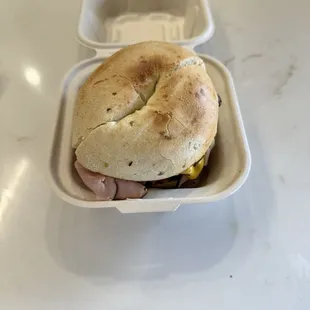 a bagel sandwich in a styrofoam container