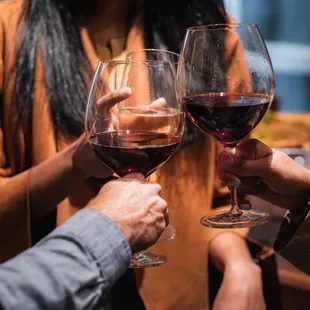 two people toasting wine glasses