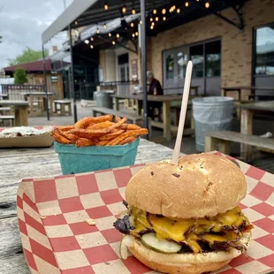a burger and fries on a picnic table