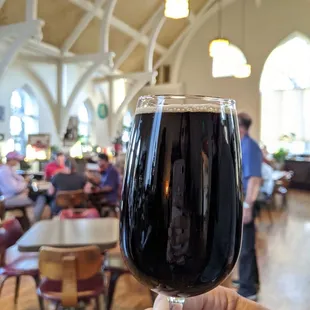 a hand holding a glass of ale