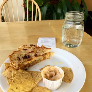 Gourmet Grilled Cheese with apples &amp; sausage. Corn chips &amp; hummus, &amp; a jar of water.
