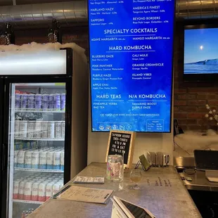 a bar counter with a menu on the wall