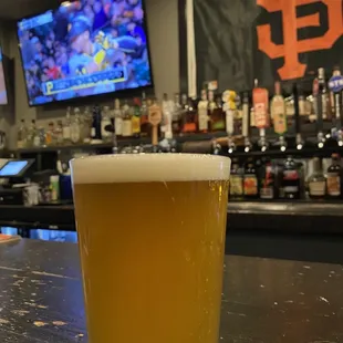 a glass of beer on a bar