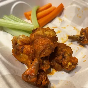 chicken wings and carrots in a styrofoam container